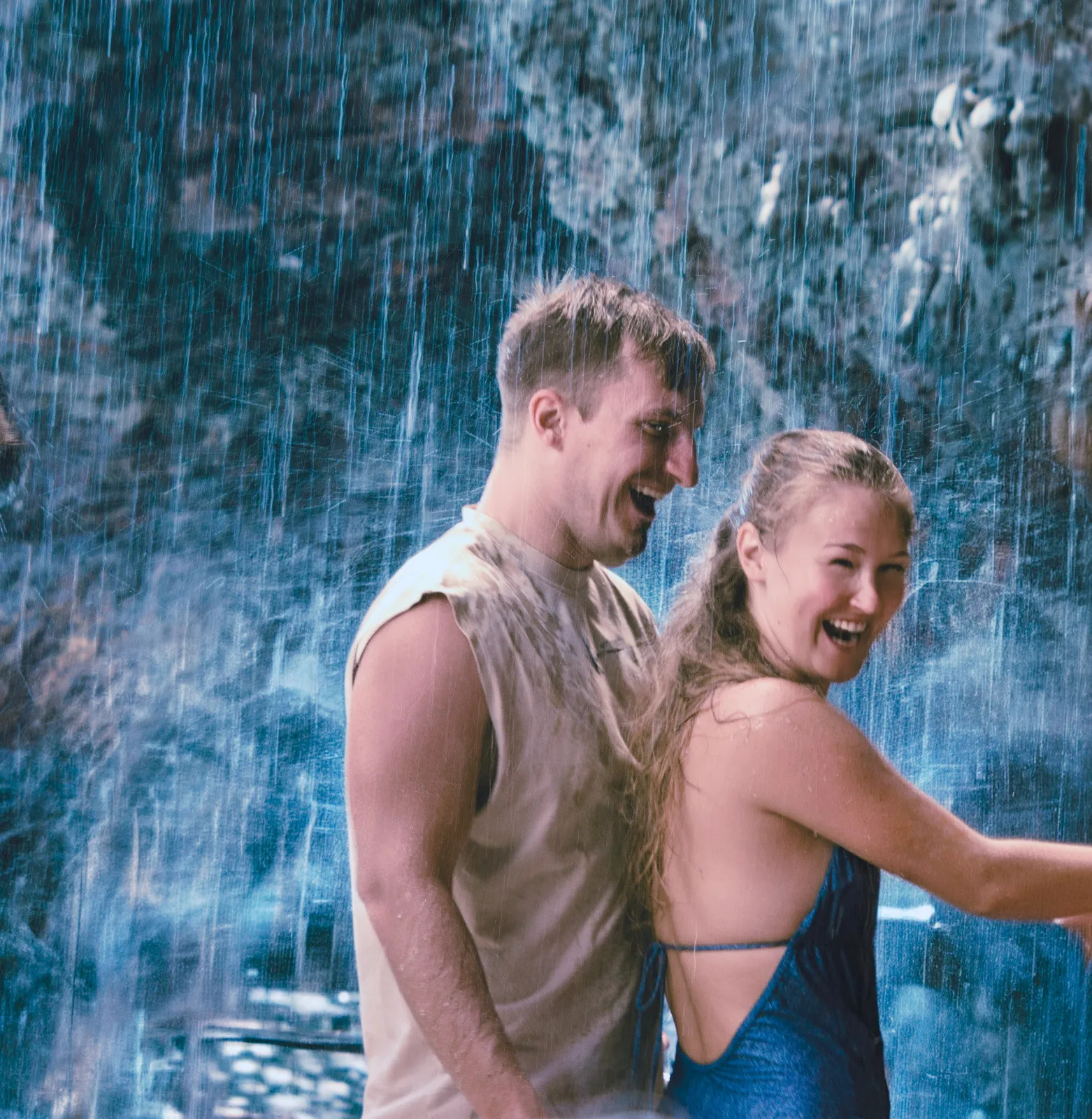 Karin und Jakob lachend im Regen vor einem Wasserfall